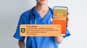 A StaffStat team member is showcasing their cell phone screen, displaying a sample of when a shift becomes available on the app.