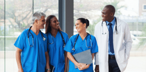 A group of medical professionals from Staffstat are seen smiling and engaging in discussions about their StaffStat schedule.